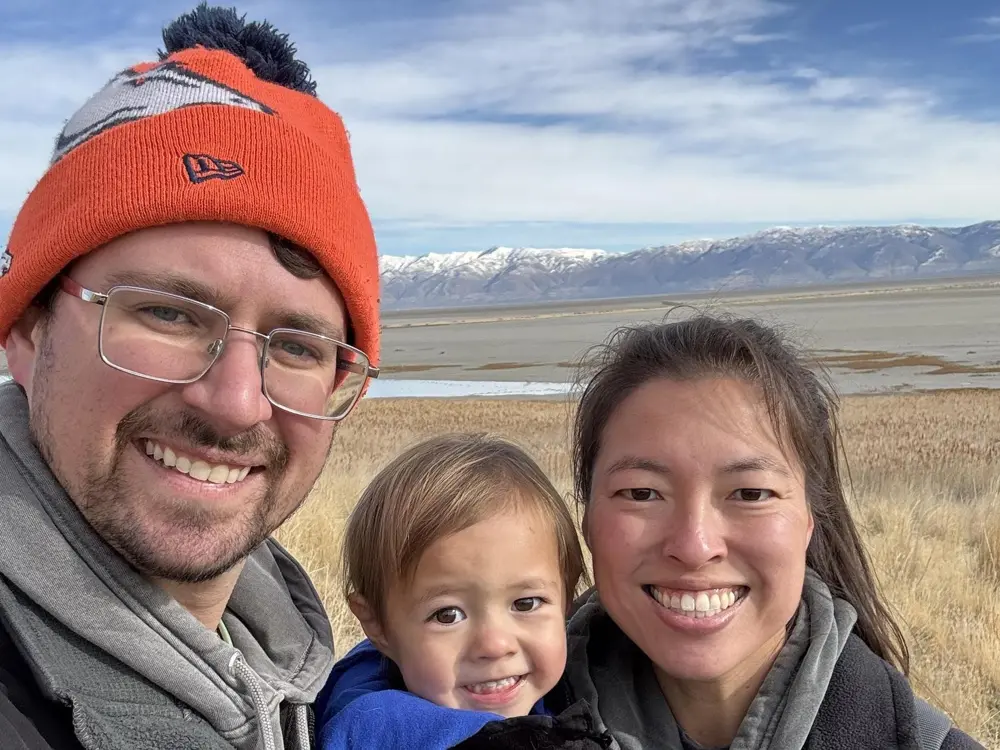 Gary, Addie and Nolan outdoors with snow-capped mountains behind them